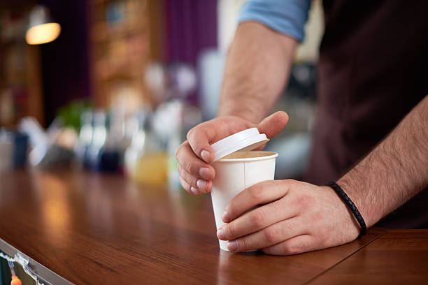 barista closing paper coffee cup
